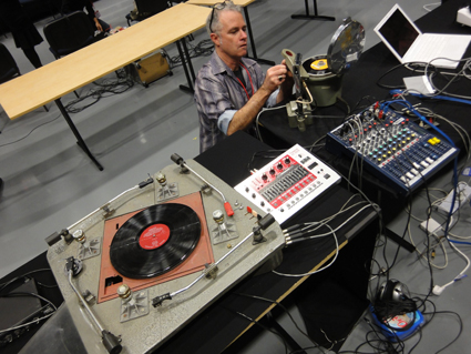 Ian Andrews preparing a medical centrifuge modified to play vinyl records at extremely high speeds, with four-arm turntable constructed by John Jacobs